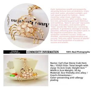 Close-up of golden crab keychain with cat's eye stone and sparkling crystals