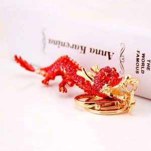 Chinese dragon keychain with red rhinestones and golden alloy ring on a white book