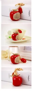 Detail of creative red apple keychain with white rhinestones and a gold metal ring