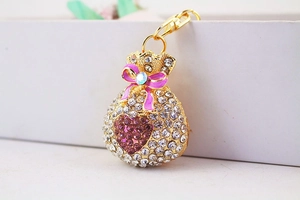 Macro detail of gold money bag keychain with crystal rhinestones and purple heart