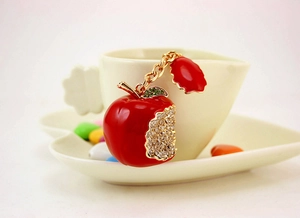 Detail of red apple keychain with sparkling white rhinestones and a gold metal chain