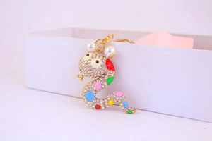 Detailed shot of the colorful snake keychain with sparkling rhinestones and white pearls