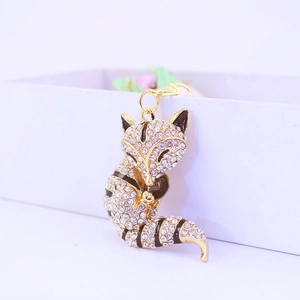 Detailed close-up of a golden fox keychain with sparkling white rhinestones and enamel