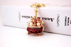 Macro detail of golden Chinese treasure bowl keychain with pearls and crystals