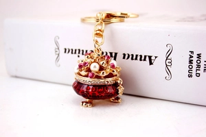 Detail of red enamel cornucopia keychain with pink gems and sparkling crystals
