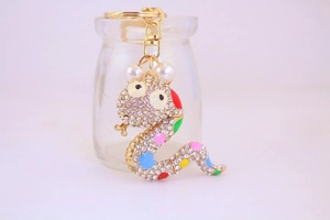 Detail of colorful rhinestone snake keychain with pearls and gold-plated finish