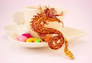 Nahaufnahme von goldenem Drachen-Schlüsselanhänger mit orangefarbenen Strasssteinen