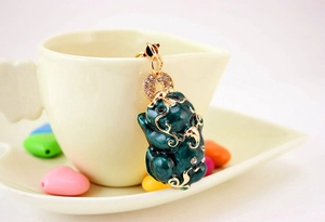 Macro shot of green enamel Pixiu keychain with sparkling rhinestones and gold alloy details