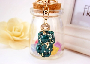 Close-up of green enamel Pixiu keychain with gold plating and sparkling rhinestones