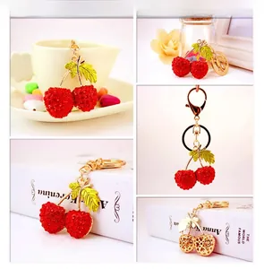 Close-up of cherry keychain with red rhinestones and gold leaves in a lifestyle setting