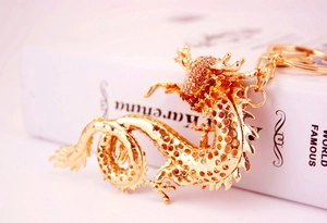 Detail eines goldenen Drachen-Schlüsselanhängers mit orangefarbenen Strasssteinen