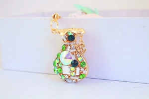 Macro view of gold money bag charm with green rhinestones and dollar sign pendant