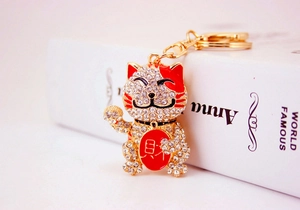 Macro view of crystal lucky cat keychain with red 'Fortune' character and metal ring