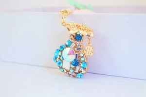 Macro detail of money bag keychain with colorful crystals and gold dollar symbol