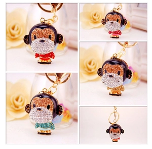 Detail view of crystal monkey keychains in various enamel colors with gold-tone hardware