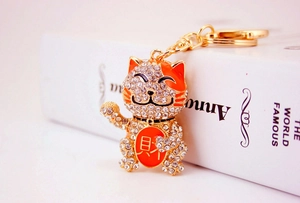 Detailed close-up of lucky cat keychain with sparkling crystals and golden alloy finish