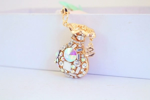 Macro shot of gold money bag charm encrusted with colorful crystals and sparkling rhinestones
