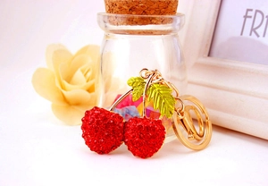 Close-up of red rhinestone cherry keychain with gold plating and lobster clasp detail