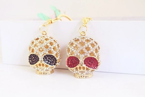 Détail du porte-clés crâne doré orné de strass blancs et d'yeux en cristal rouge et noir
