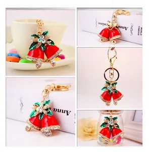 Detailed views of red Christmas bell keychain with green leaves and golden hardware