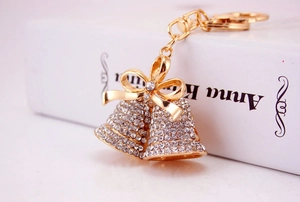 Macro detail of golden bell keychain with sparkling rhinestones and a metal bow