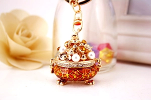 Detail of red enamel treasure bowl keychain with pearls and sparkling zircons