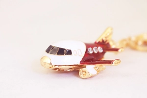 Macro detail of A380 airplane keychain with red enamel finish and sparkling crystals