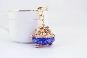 Detail of blue enamel censer pendant with gold hardware and white pearl accents