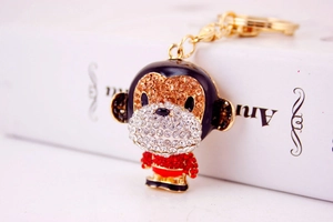 Detailed view of monkey keychain with white and brown rhinestones on gold chain