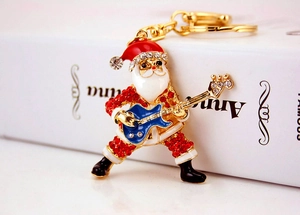 Macro detail of Santa Claus guitar keychain with vibrant red enamel and sparkling rhinestones