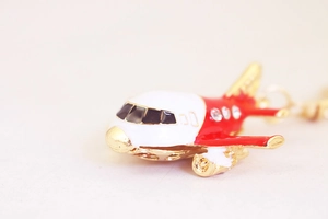 Detailed macro view of a red and white A380 airplane pendant with tiny crystals and gold trim