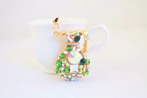 Detail view of golden money bag keychain with green rhinestones and a dollar sign charm