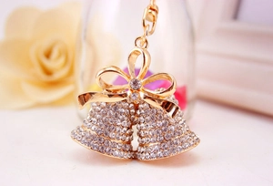 Close-up of sparkling golden bell keychain with rhinestone bow and luxury finish