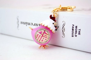 Dettaglio del portachiavi a pulcino in smalto rosa con placcatura in oro e strass