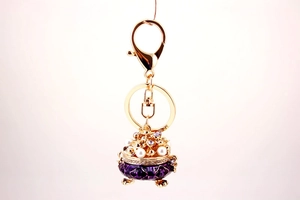 Detail of luxury purple enamel incense burner keychain with pearls and crystals