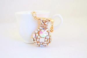 Close-up of golden money bag keychain encrusted with crystal rhinestones and dollar charm
