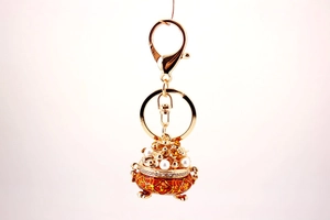 Detailed view of golden Chinese fortune bowl keychain with pearls and red Fu character