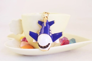 Close-up of a creative A380 airplane keychain with blue enamel and rhinestones on a cup