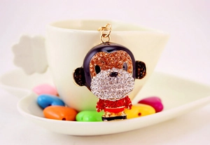 Detailed macro view of a gold alloy monkey keychain with vibrant red and brown rhinestones
