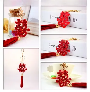 Detail of red crystal Xi character keychain with decorative tassel and golden knot