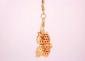 Detailed close-up of golden lucky cat keychain with hollow design and crystal accents