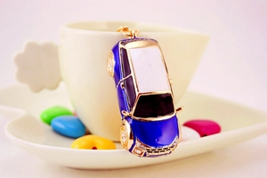 Dettaglio di un portachiavi auto blu con strass appeso su una tazza di ceramica