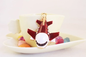 Detail of red and white enamel airplane keychain with sparkling crystal embellishments