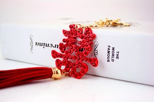 Macro detail of red rhinestone crystal Double Happiness keychain with long velvet tassel