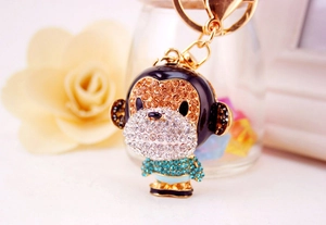 Detailed view of monkey keychain featuring sparkling rhinestones on golden metal