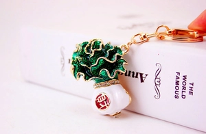 Close-up of cabbage keychain with green enamel, gold plating and sparkling crystal detail
