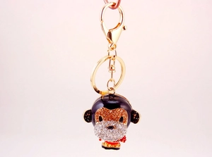 Close-up of cute monkey keychain with black enamel, brown rhinestones and gold lobster clasp