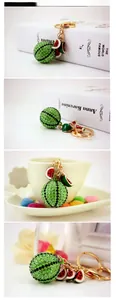 Sparkling watermelon rhinestone keychain with green pave ball on a lifestyle background