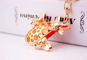 Detailed close-up of a golden A380 airplane keychain with red wings and rhinestone accents