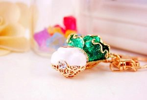 Macro detail of cabbage keychain with green enamel, gold finish, and crystal inlay